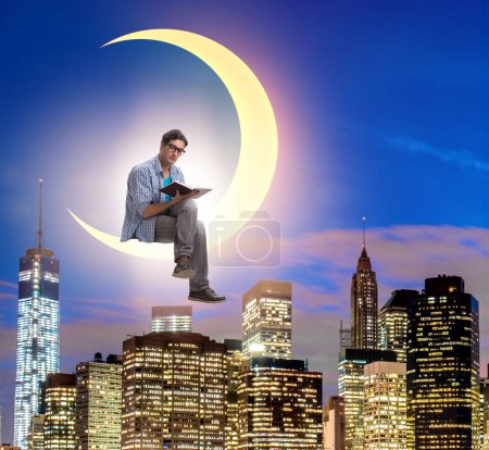 Téléchargez les photos : L'étudiant lisant le livre sur le croissant de lune - en image libre de droit