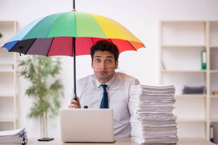Photo for Young employee holding an umbrella at workplace - Royalty Free Image