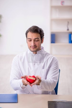 Photo for Young doctor cardiologist holding heart model - Royalty Free Image