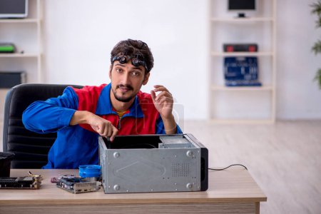 Photo for Young repairman repairing computer at workshop - Royalty Free Image