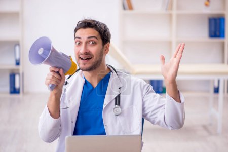 Photo for Young doctor holding megaphone at the hospital - Royalty Free Image
