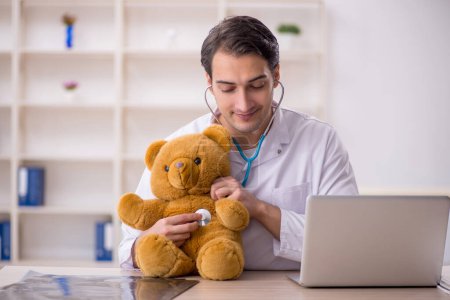 Foto de Joven doctor sosteniendo juguete oso - Imagen libre de derechos