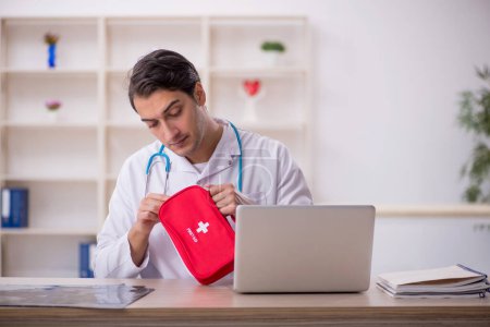 Photo for Young doctor paramedic holding first aid bag - Royalty Free Image