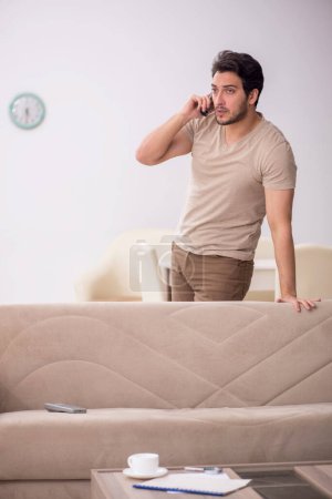 Photo for Young male student speaking by phone during pandemic - Royalty Free Image