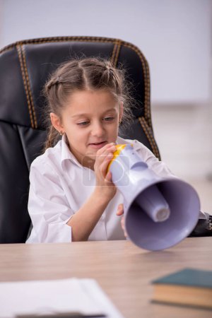 Téléchargez les photos : Little girl holding megaphone in the classroom - en image libre de droit
