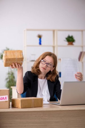 Photo for Young businesswoman working in box delivery service - Royalty Free Image