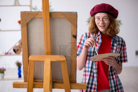 Téléchargez les photos : Jeune étudiante appréciant la peinture à la maison - en image libre de droit