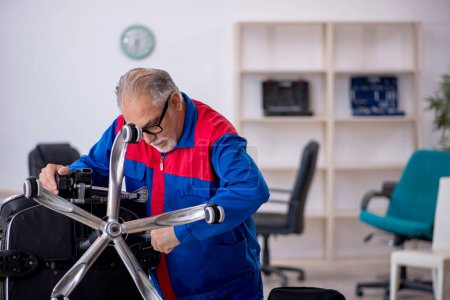 Photo for Old repairman repairing office chair - Royalty Free Image