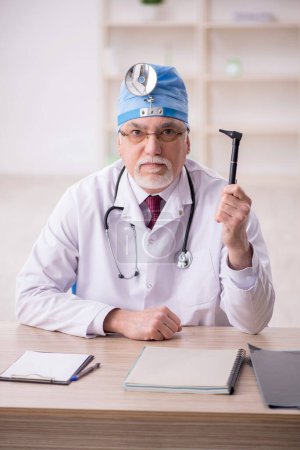 Photo for Old doctor otorhinolaryngologist working in the clinic - Royalty Free Image