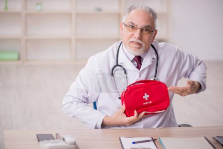 Foto de Viejo médico sosteniendo bolsa de primeros auxilios - Imagen libre de derechos