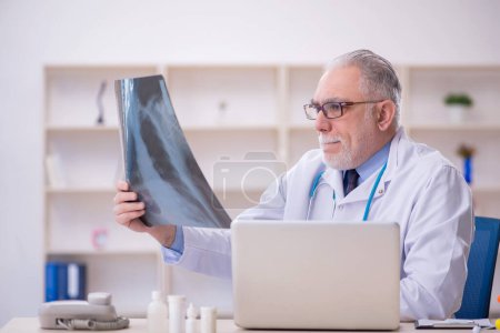 Photo for Old doctor radiologist working in the clinic - Royalty Free Image
