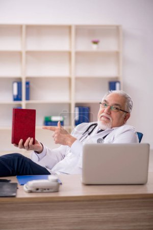 Photo for Aged male doctor working in the clinic - Royalty Free Image