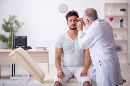 Téléchargez les photos : Jeune patient visitant un vieux médecin masculin - en image libre de droit