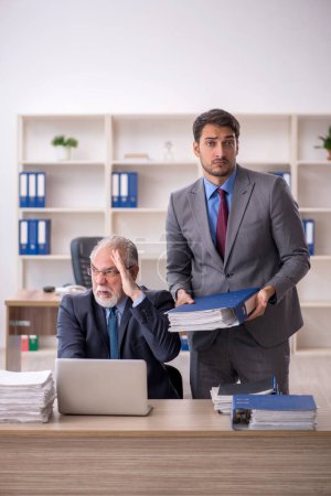 Téléchargez les photos : Deux collègues masculins travaillant sur le lieu de travail - en image libre de droit