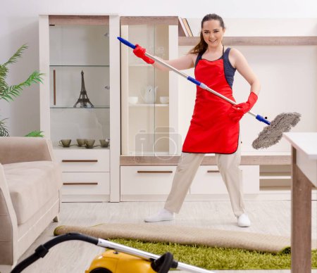 Foto de The young beautiful woman cleaning apartment - Imagen libre de derechos
