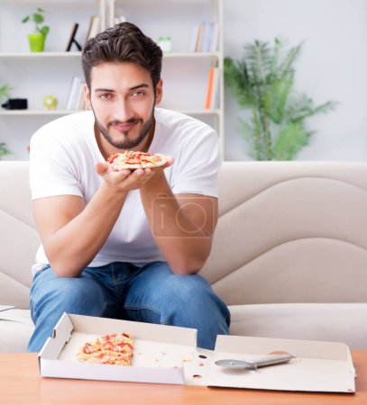 Foto de El hombre comiendo pizza teniendo una comida para llevar en casa descansando relajado - Imagen libre de derechos