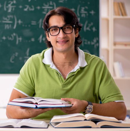 Foto de El estudiante guapo delante de pizarra con fórmulas - Imagen libre de derechos
