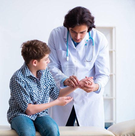 Téléchargez les photos : Le garçon blessé à la main visitant un jeune médecin masculin - en image libre de droit