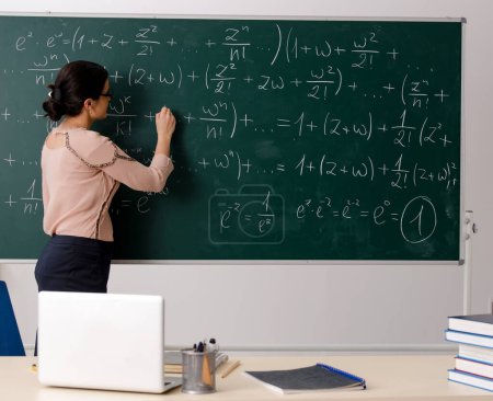 Photo for The female teacher standing in front of chalkboard - Royalty Free Image
