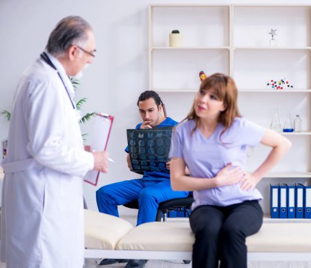 Photo for The two doctors examining young woman - Royalty Free Image