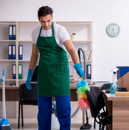 Photo for The young handsome contractor cleaning the office - Royalty Free Image