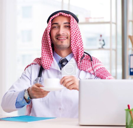 Téléchargez les photos : Le médecin arabe travaillant à la clinique - en image libre de droit