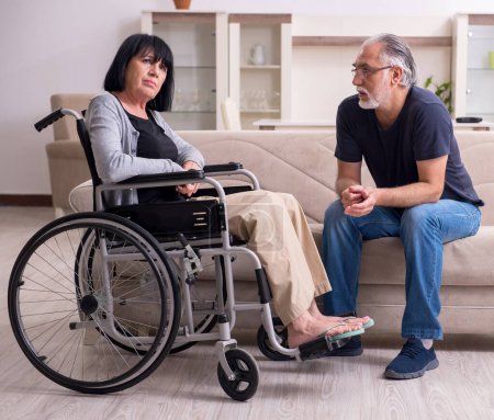 Téléchargez les photos : Le vieux mari qui s'occupe de sa femme handicapée - en image libre de droit