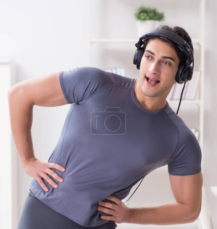 Photo for The man doing sports at home and listening to music - Royalty Free Image
