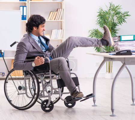 Photo for The young handsome employee in wheelchair at the office - Royalty Free Image