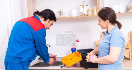 Photo for The young male repairman repairing tap - Royalty Free Image