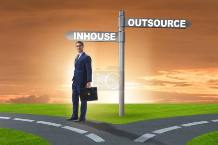 Foto de Empresario en encrucijada decidiendo entre outsourcing e inhouse - Imagen libre de derechos