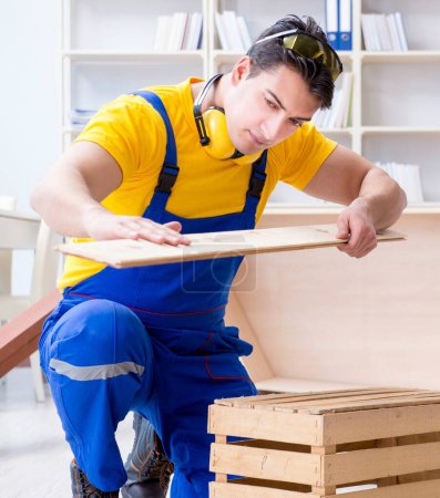 Téléchargez les photos : Le réparateur charpentier inspectant l'examen d'une planche de bois - en image libre de droit