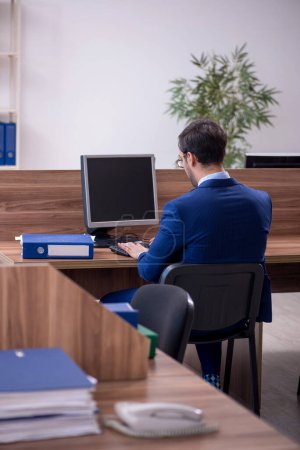 Téléchargez les photos : Jeune homme d'affaires employé travaillant dans le bureau - en image libre de droit