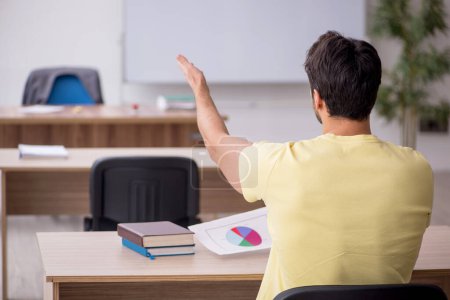Téléchargez les photos : Young student teacher sitting in the classroom - en image libre de droit