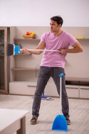 Foto de Joven contratista limpiando la casa - Imagen libre de derechos