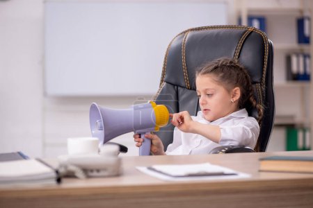 Téléchargez les photos : Little girl holding megaphone in the classroom - en image libre de droit