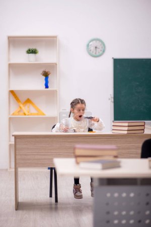 Téléchargez les photos : Petite fille assise dans la classe - en image libre de droit