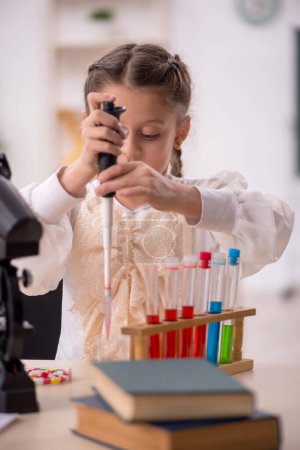 Foto de Little girl studying chemistry in the classroom - Imagen libre de derechos