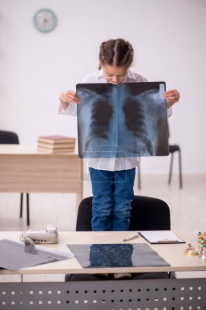 Téléchargez les photos : Little girl playing doctor radiologist at the hospital - en image libre de droit