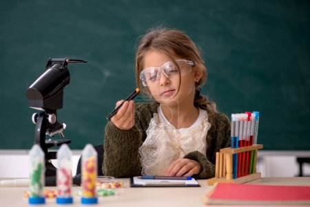Téléchargez les photos : Jeune fille chimiste dans la salle de classe - en image libre de droit