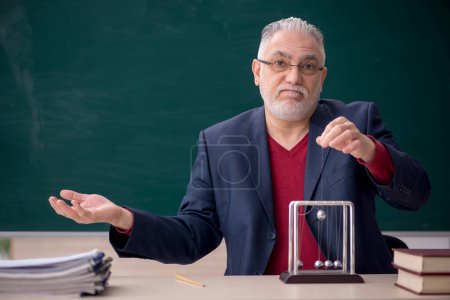 Photo for Old teacher physicist sitting in the classroom - Royalty Free Image
