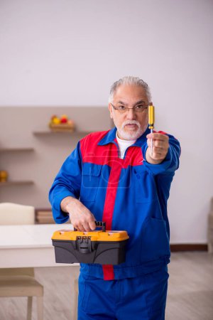 Téléchargez les photos : Vieux charpentier travaillant à la maison - en image libre de droit