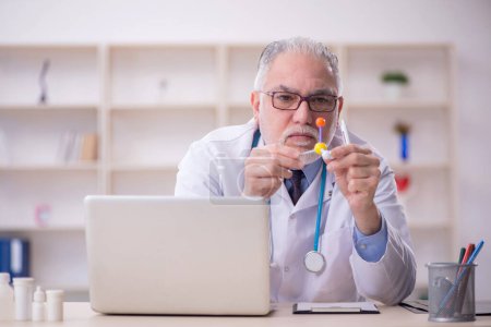 Téléchargez les photos : Old doctor holding molecular model at the hospital - en image libre de droit