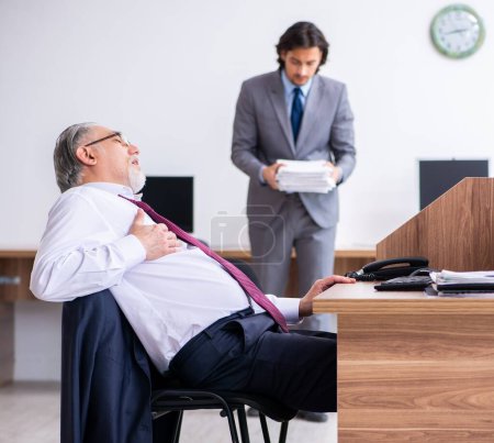 Téléchargez les photos : L'employé masculin souffrant d'une crise cardiaque au bureau - en image libre de droit