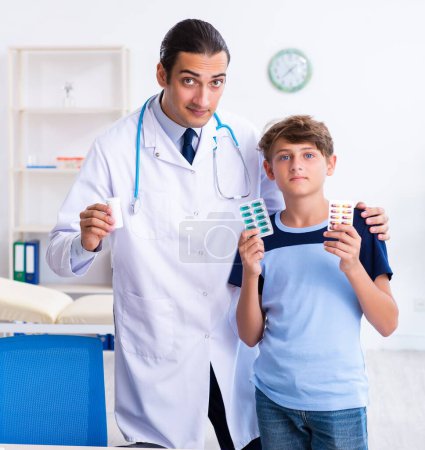 Foto de El joven médico examinando a un niño en la clínica - Imagen libre de derechos