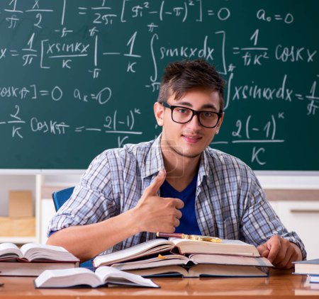 Foto de El joven estudiante que estudia matemáticas en la escuela - Imagen libre de derechos