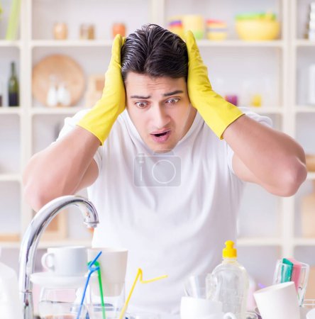 Foto de El hombre frustrado por tener que lavar los platos - Imagen libre de derechos