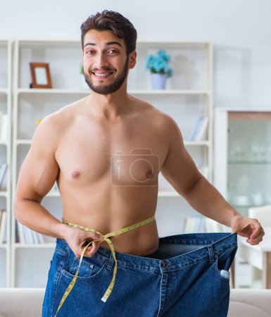 Foto de El hombre en pantalones de gran tamaño en concepto de pérdida de peso - Imagen libre de derechos