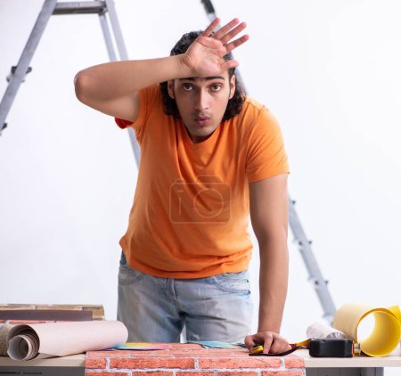 Photo for The young man contractor doing renovation at home - Royalty Free Image