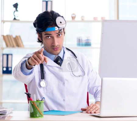 Téléchargez les photos : Le jeune beau médecin otolaryngologue devant tableau blanc - en image libre de droit